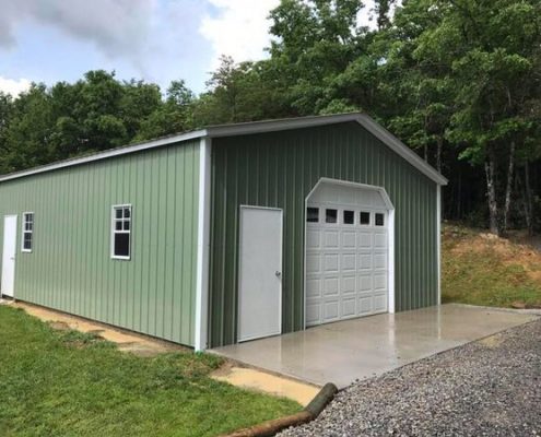 green metal building with garage style doors