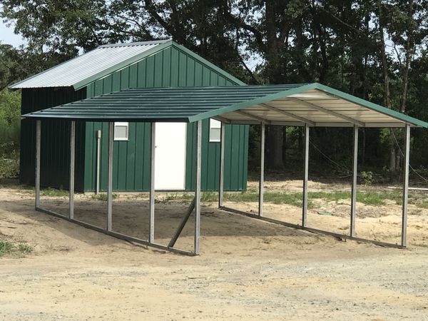 green carport in front of shed